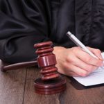 Close-up Of A Judge Hitting Mallet At Desk